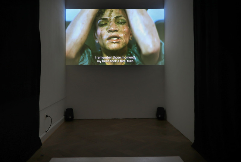 Filmausschnitt einer Frau, die eine Ananas über ihrem Gesicht zerdrückt