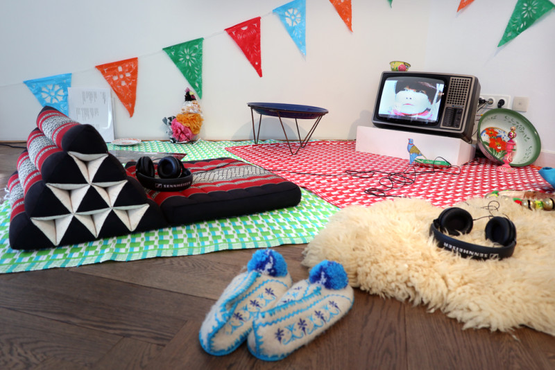 ein Schafsfell, Teppiche und Stoffschuhe liegen auf dem Boden