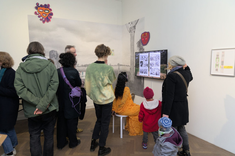 A group of people stand in front of the multimedia installation 