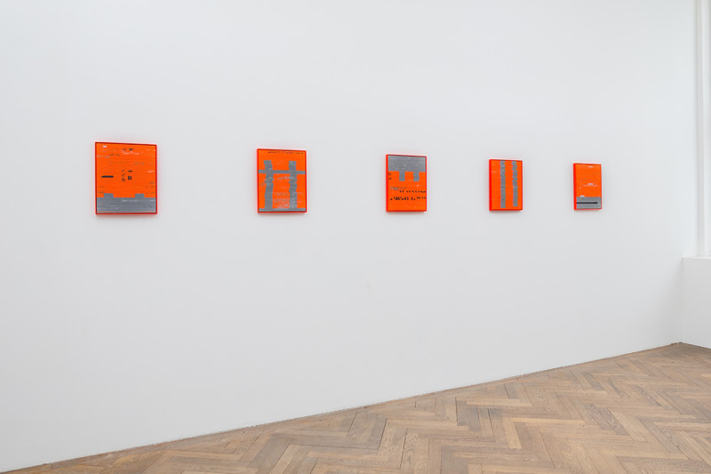 Neon-Orrangene Webarbeiten hängen an einer Wand