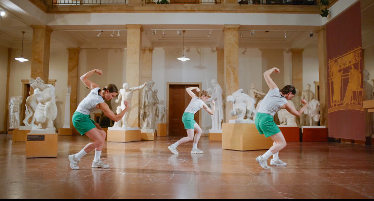 drei Tänzerinnen posieren vor griechischen Skulpturen